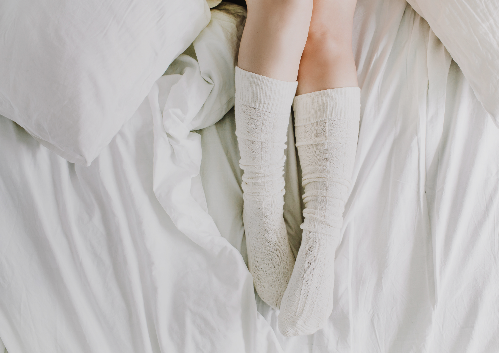 Image of legs with socks in bed